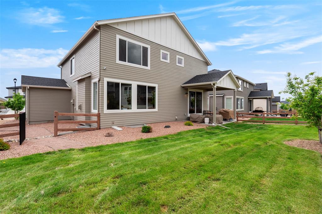 Image 39 of 43: Rear view of house with a patio and board and batten siding
