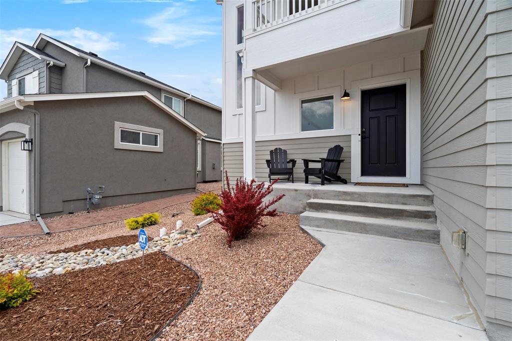 Image 4 of 43: Doorway to property featuring stucco siding and an attached garage