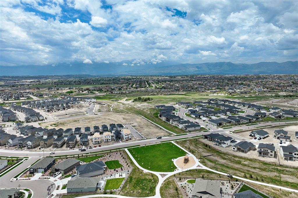 Image 42 of 43: Aerial view of residential area featuring a mountainous background