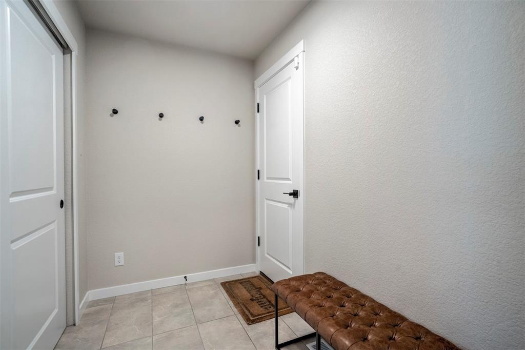 Image 6 of 43: Mudroom featuring light tile patterned floors and baseboards