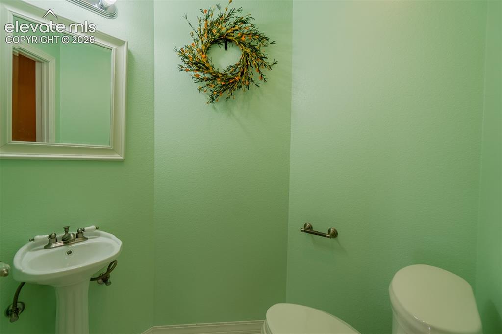 Image 10 of 41: Stylish powder room offers added convenience for family and visitors.