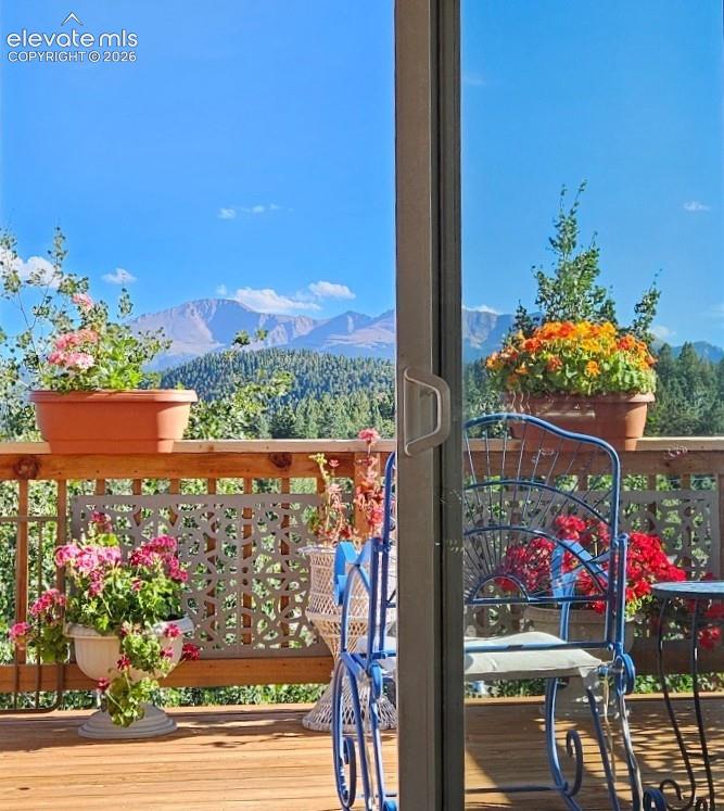 Image 20 of 45: Sliding glass door leading to a wood-plank deck with a decorative railing a