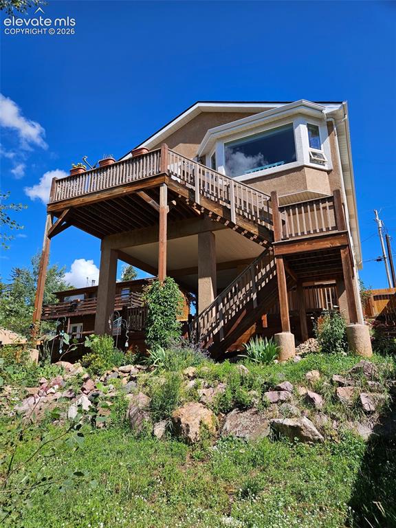 Image 38 of 45: Multi-level exterior featuring a bay window, expansive wood deck, wood-rail