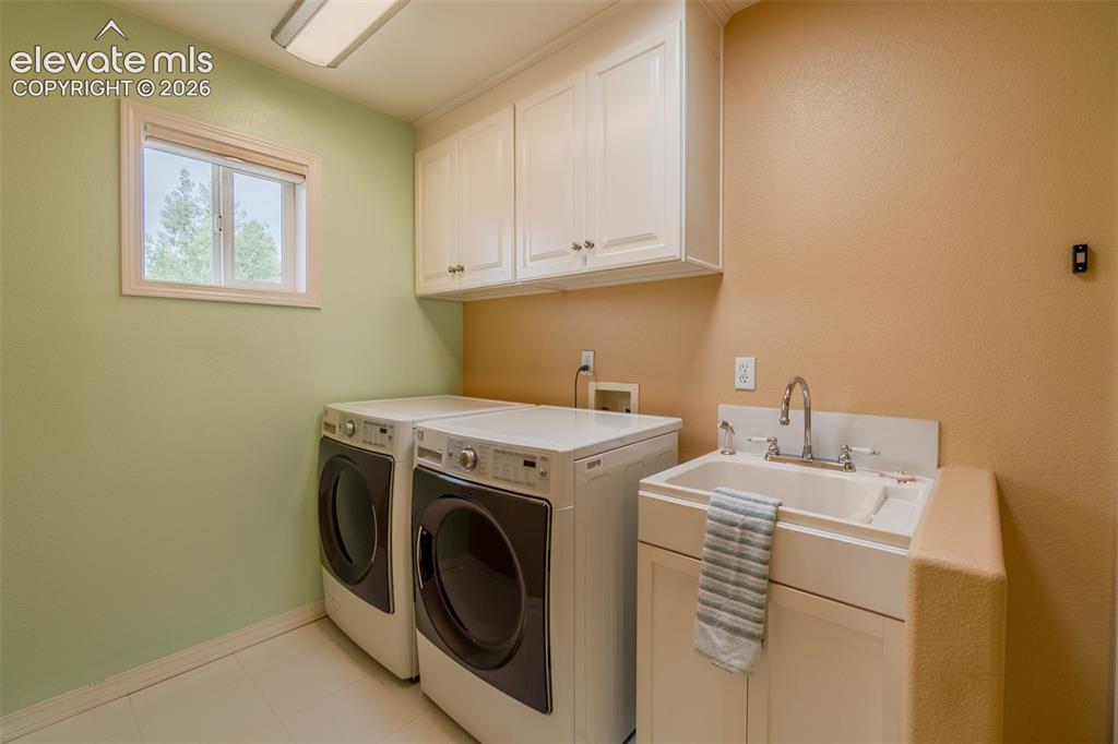 Image 9 of 41: Convenient main-level laundry room with built-in cabinetry for extra storag