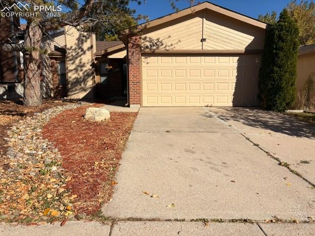 Image 2 of 28: View of front of property featuring concrete driveway, brick siding, and a