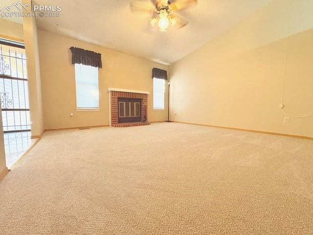 Image 3 of 28: Unfurnished living room with carpet floors, a fireplace, ceiling fan, and v