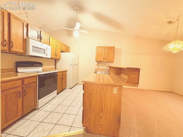 Image 7 of 28: Kitchen featuring white appliances, light countertops, a peninsula, a kitch