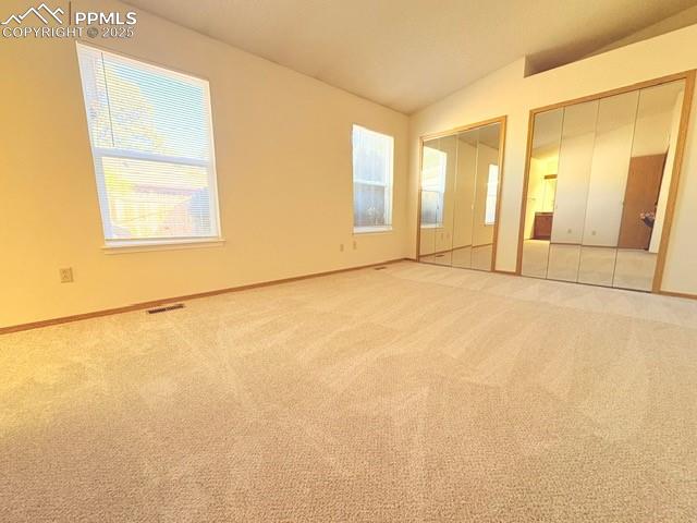 Image 9 of 18: Unfurnished bedroom featuring multiple closets, carpet flooring, and vaulte