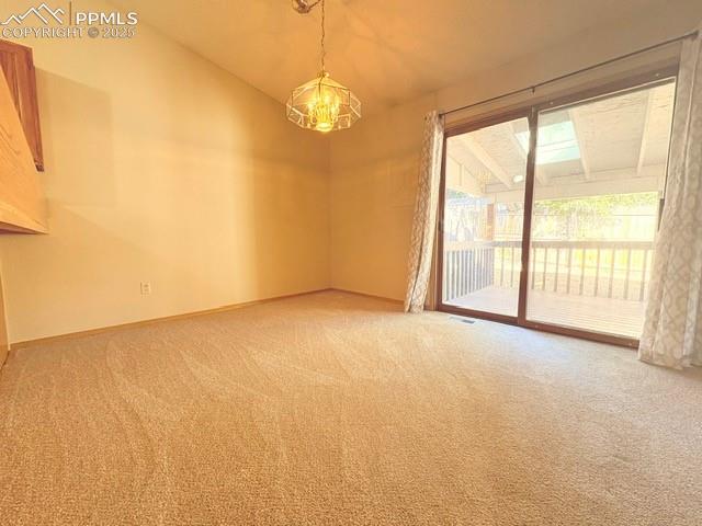Image 9 of 28: Empty room featuring light colored carpet and a chandelier