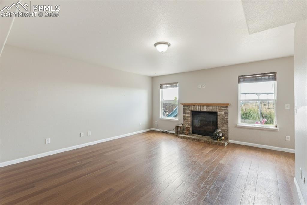 Image 16 of 41: Unfurnished living room with plenty of natural light, wood-type flooring, a