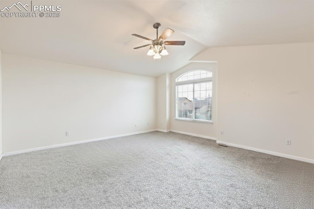 Image 20 of 41: Empty room featuring light carpet, lofted ceiling, and a ceiling fan