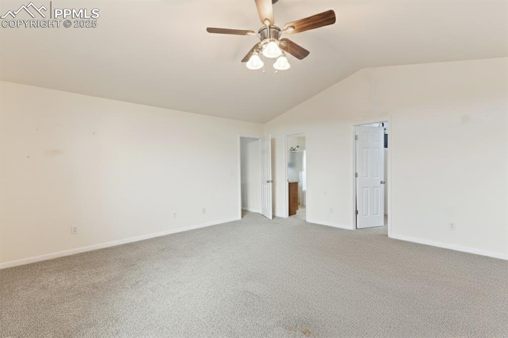 Image 21 of 41: Unfurnished bedroom featuring vaulted ceiling, carpet floors, ensuite bath,