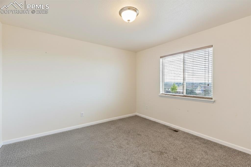 Image 25 of 41: Spare room featuring baseboards and carpet
