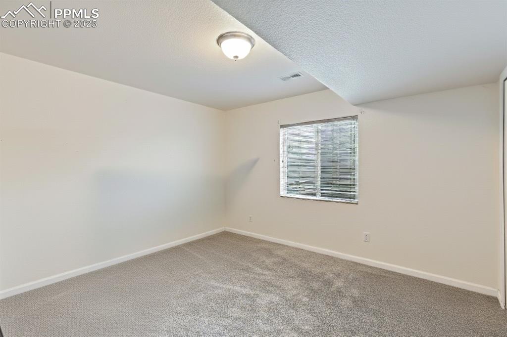 Image 29 of 41: Carpeted empty room featuring baseboards and a textured ceiling