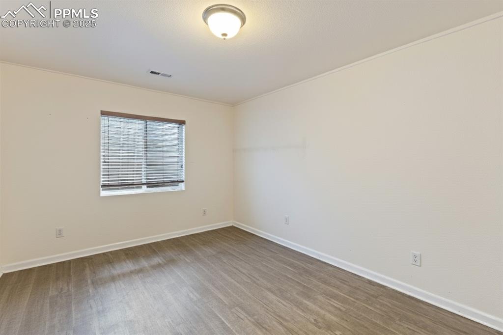Image 31 of 41: Spare room featuring wood finished floors and crown molding