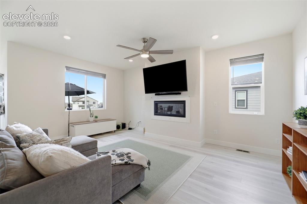 Image 4 of 49: A modern gas fireplace creates a welcoming warmth to the open floor plan. 