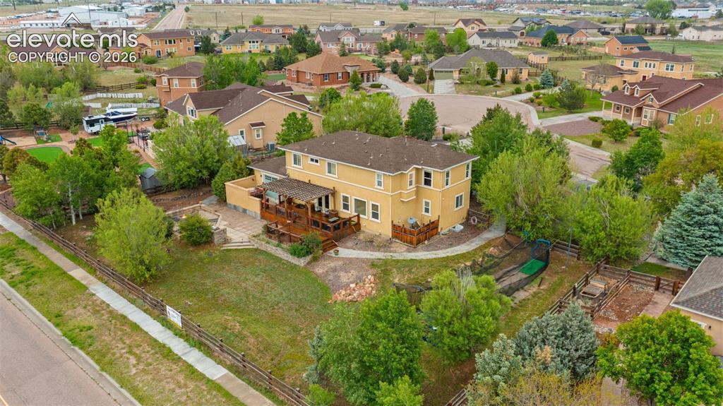 Image 32 of 45: Yellow exterior with multiple decks, extensive landscaping, and a fenced ya