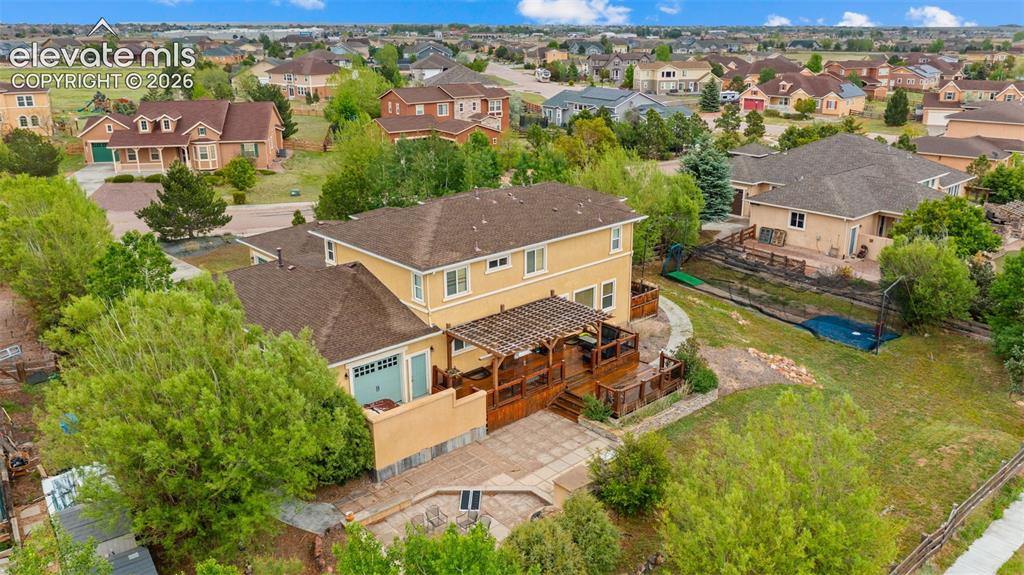 Image 33 of 45: Two-story residence with a stucco exterior and shingle roof
