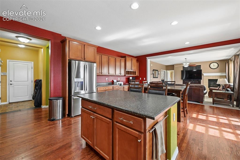 Image 7 of 45: Kitchen featuring a central island with a dark countertop, wood-finish cabi