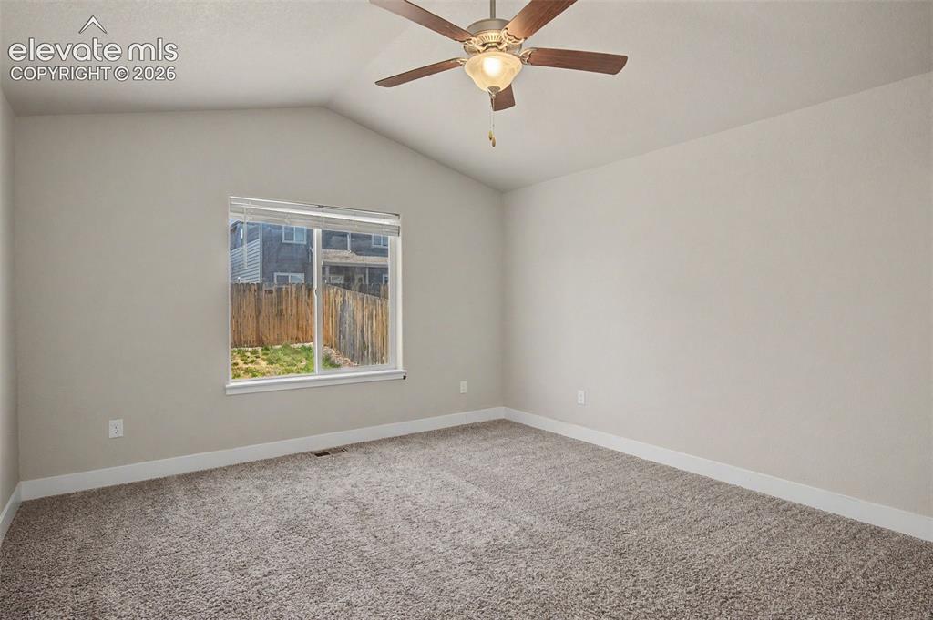 Image 22 of 44: Carpeted room featuring a vaulted ceiling and a ceiling fan with integrated