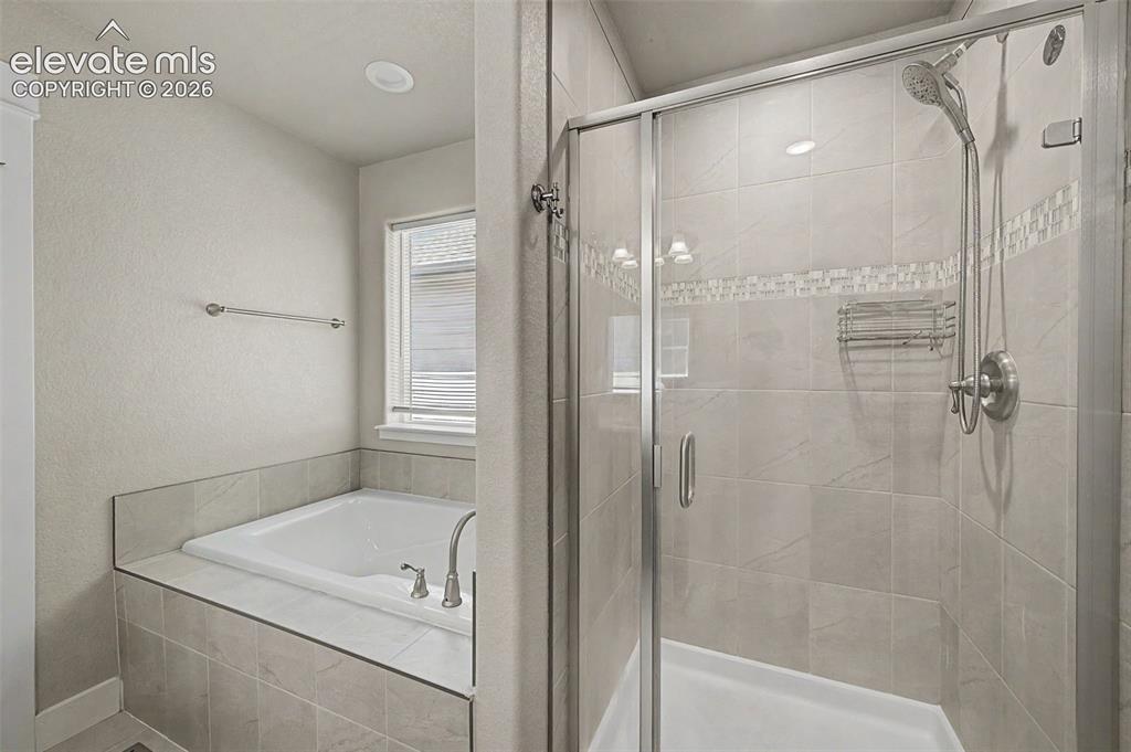 Image 25 of 44: Bathroom featuring a glass-enclosed shower with tile surround, a built-in t