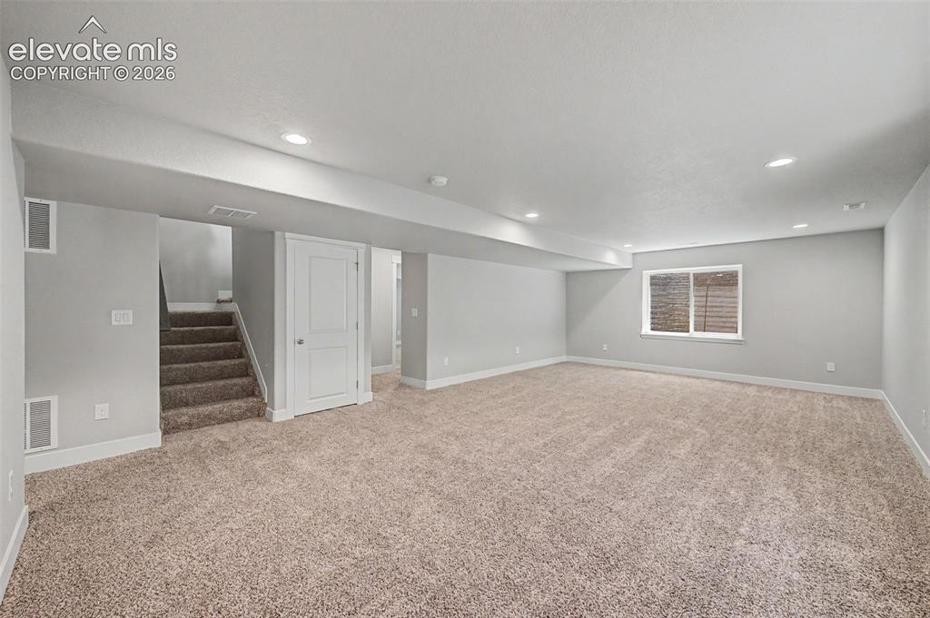 Image 34 of 44: Spacious carpeted room featuring recessed lighting, a window with horizonta