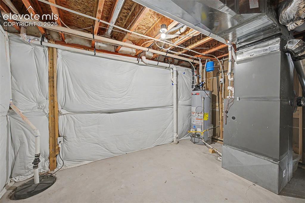 Image 41 of 44: Unfinished basement space featuring a water heater, furnace, exposed ceilin