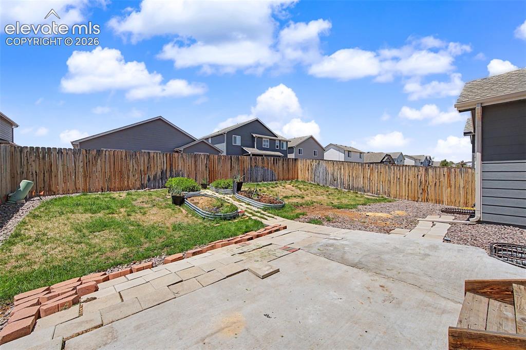 Image 42 of 44: Expansive backyard featuring a concrete patio, brick edging, a wood privacy