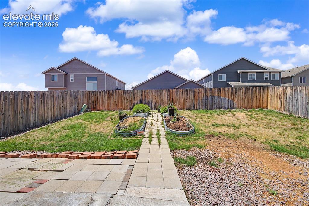 Image 43 of 44: Spacious backyard featuring a wood privacy fence, a stone paver patio, a pa