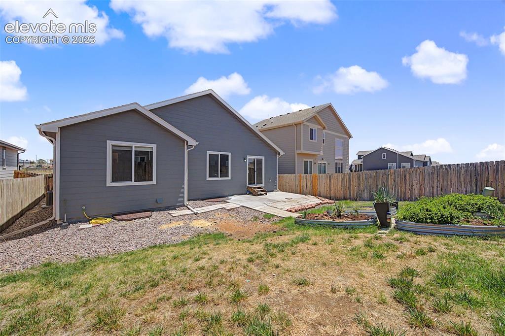 Image 44 of 44: Rear exterior with gray siding, multiple windows, and a sliding glass door