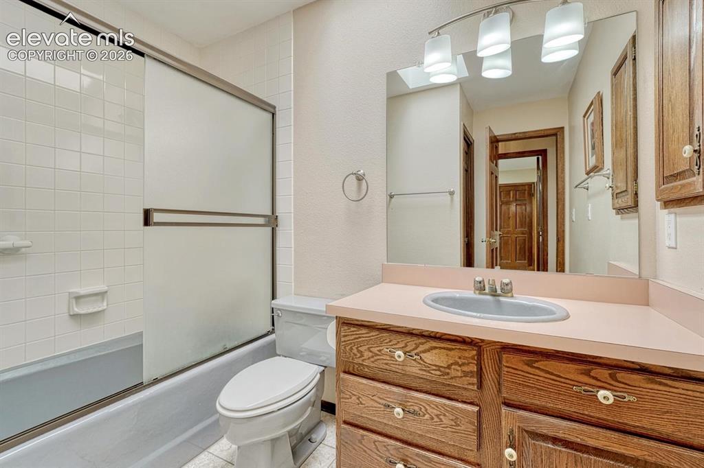 Image 20 of 48: Full hall bathroom with skylight serves the second and third bedrooms.
