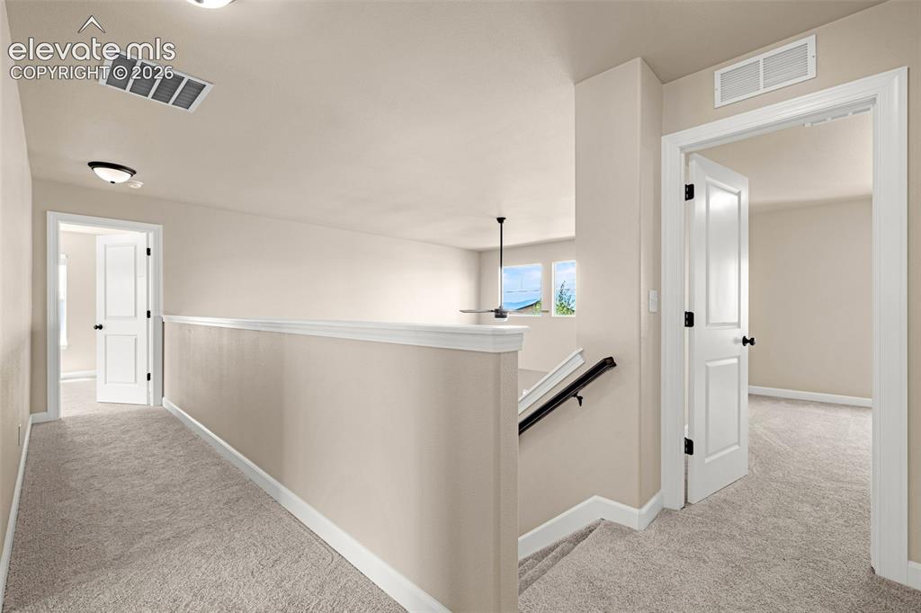 Image 15 of 42: Cat walk overlooks the Great Room and has wall of windows with Pikes Peak v