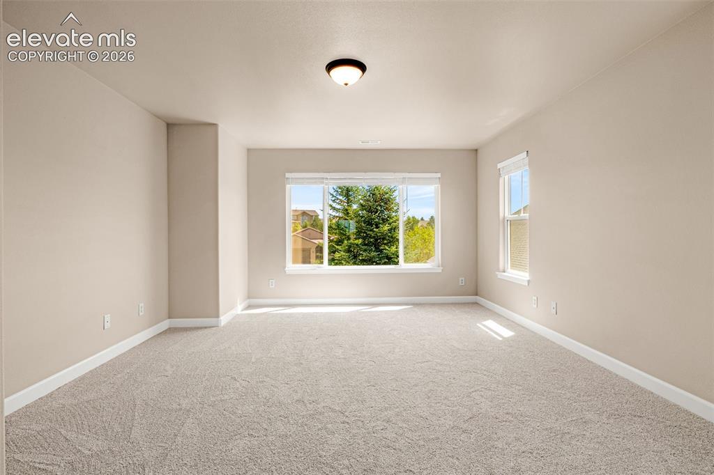 Image 18 of 42: Secluded primary bedroom is bright and expansive. New carpet, paint, baseb
