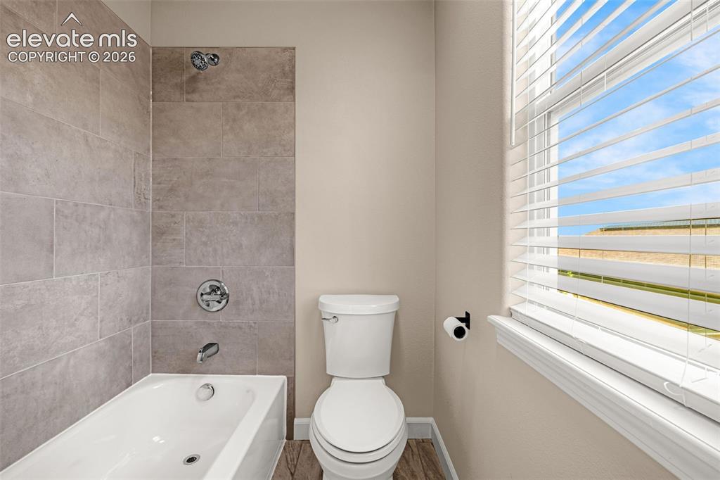 Image 23 of 42: Upper level shared bathroom has separate water closet and bath/tub combo.