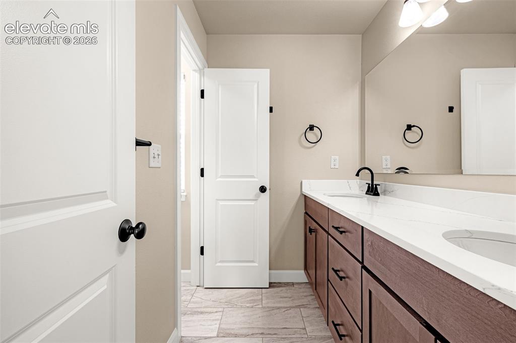 Image 24 of 42: Upper level shared bathroom with dual sinks, new cabinet, hardware and tile