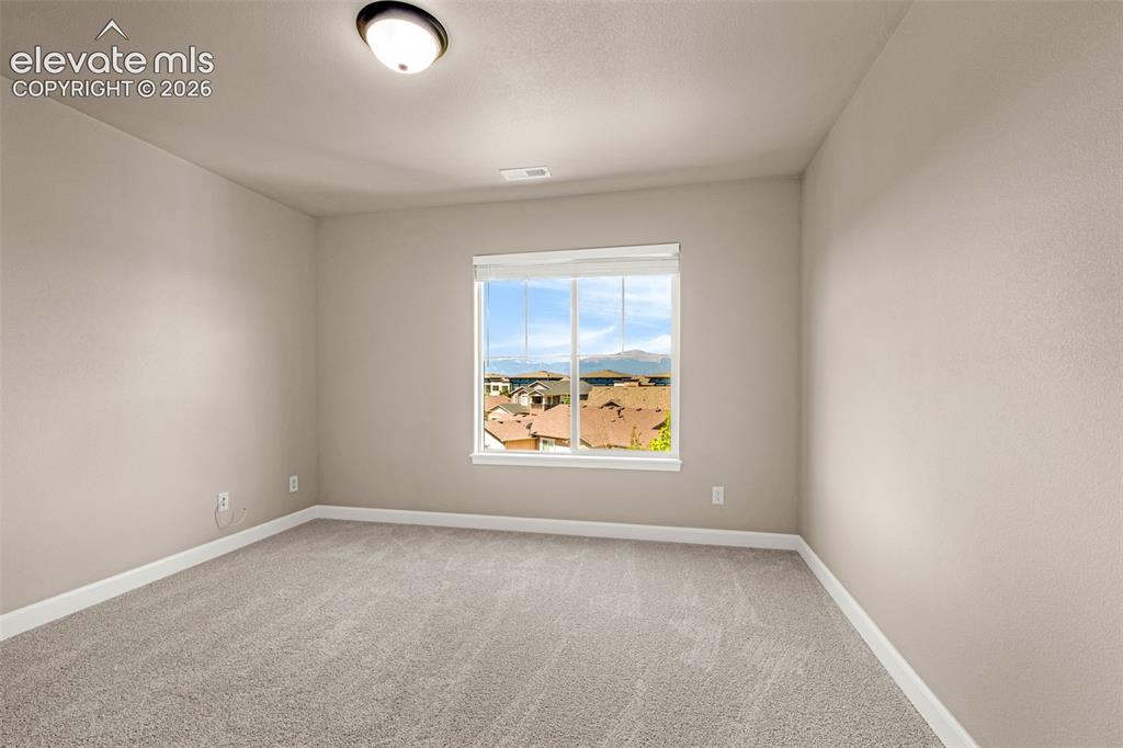 Image 26 of 42: 3rd Upper level bedroom with Pikes Peak and Front range views and new carpe