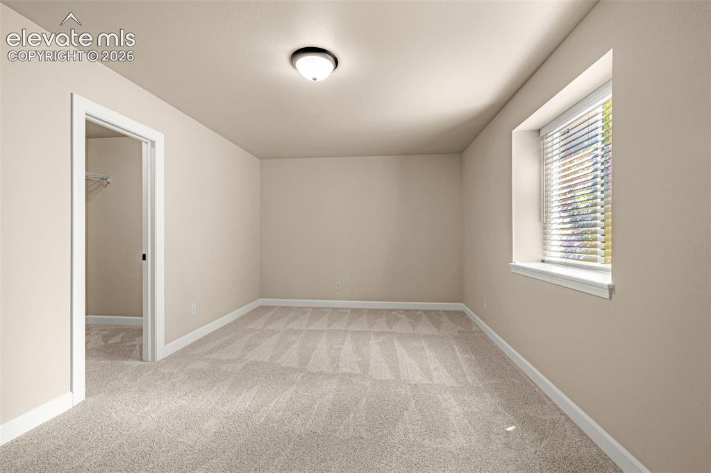 Image 31 of 42: 5th bedroom is located in the basement and is large enough for guests, sitt