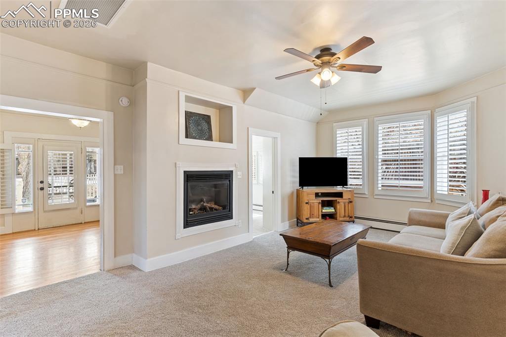 Image 11 of 36: Light and bright living room with gas fireplace; new carpet and pad just in