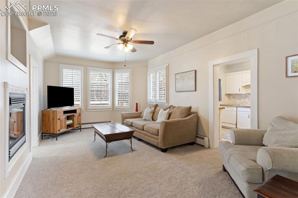 Image 12 of 36: Light and bright living room with gas fireplace; new carpet and pad just in