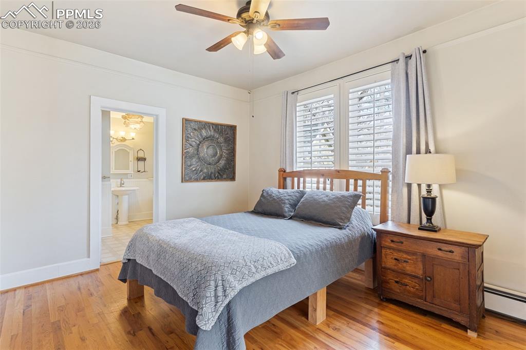 Image 18 of 36: Large, beautiful primary bedroom with hardwood floors, high ceilings, attac