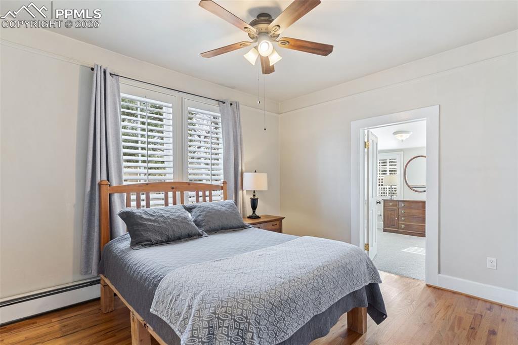 Image 19 of 36: Large, beautiful primary bedroom with hardwood floors, high ceilings, attac