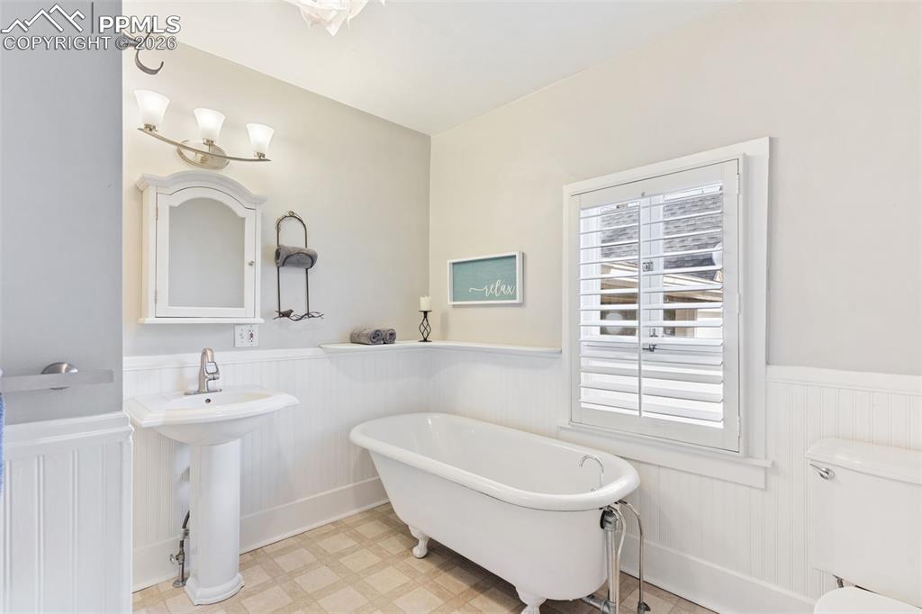 Image 22 of 36: Graceful, spacious bathroom with claw foot tub and separate shower.