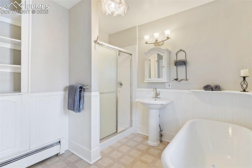 Image 23 of 36: Graceful, spacious bathroom with claw foot tub and separate shower.