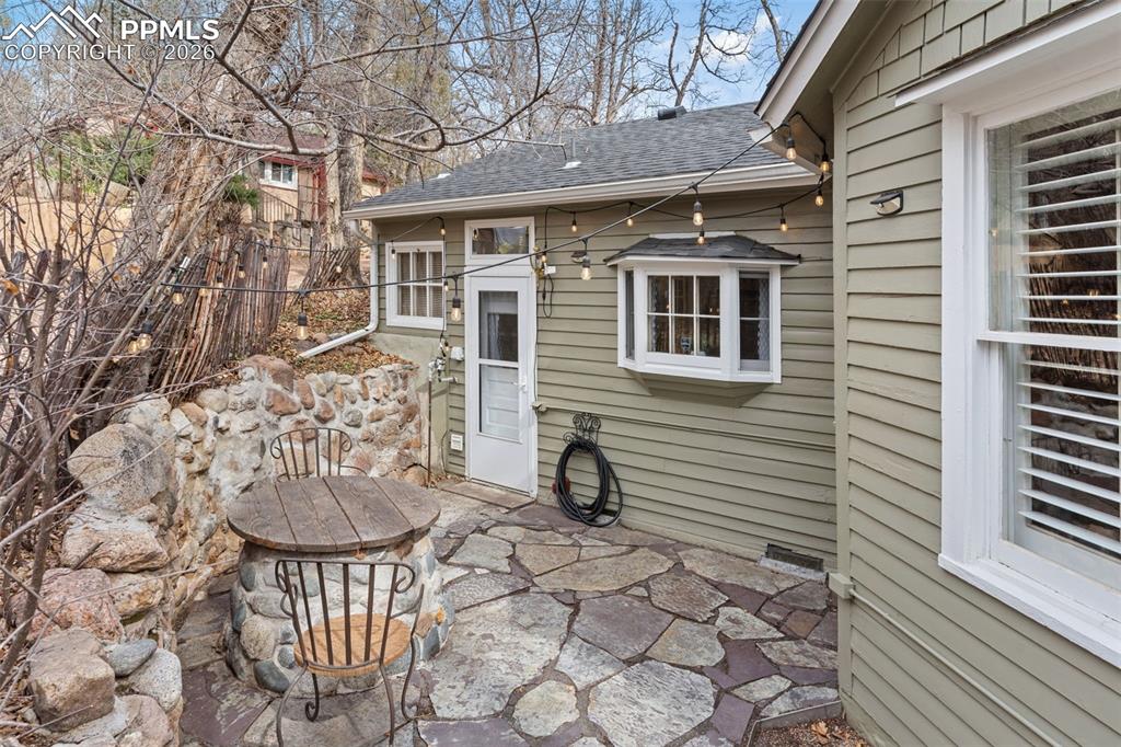 Image 30 of 36: Side patio, with beautiful pavers, is off the kitchen and laundry room and