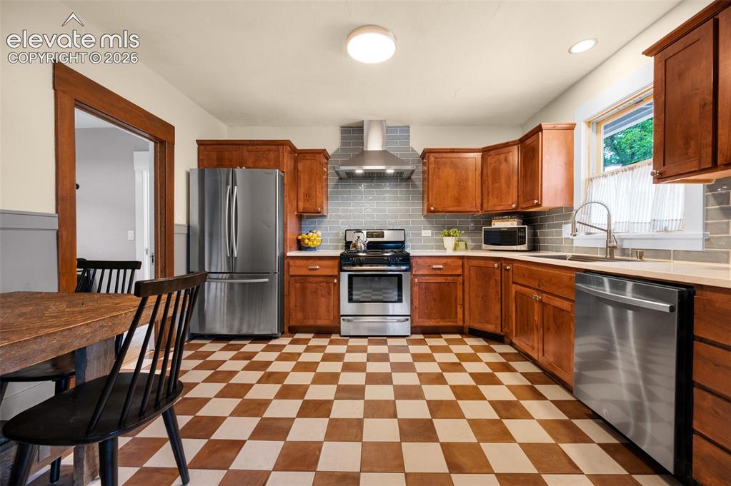 Image 15 of 50: Newly remodeled kitchen with new tile floors, cabinets, counters and hood.