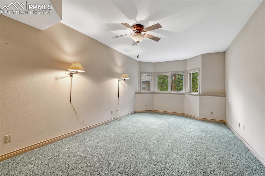 Image 44 of 49: Third of three basement bedrooms with above grade windows, ceiling fan...