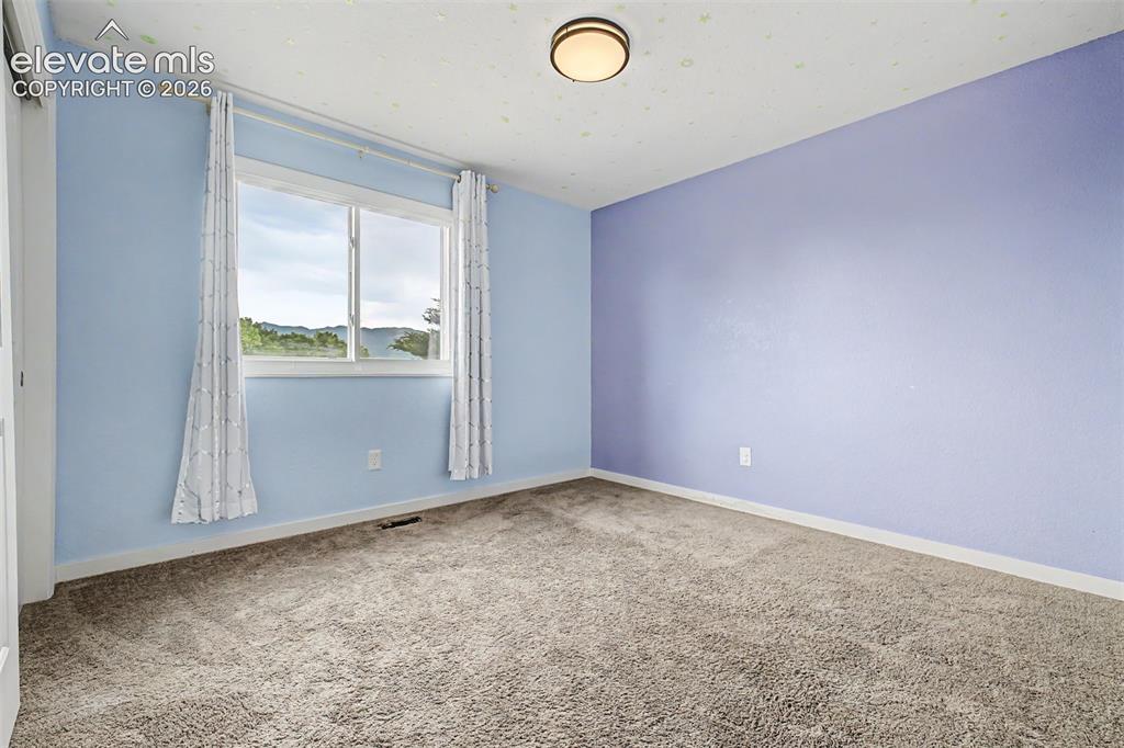 Image 16 of 44: Second bedroom on the main level has amazing mountain views too! 