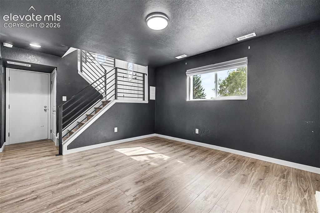 Image 21 of 44: Lower level family room with stone fireplace offers a second area for enter