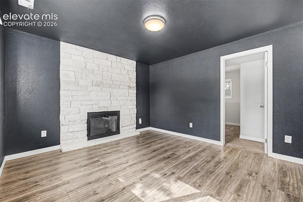 Image 23 of 44: Wood burning fireplace, natural light and newer LVP flooring make this an i