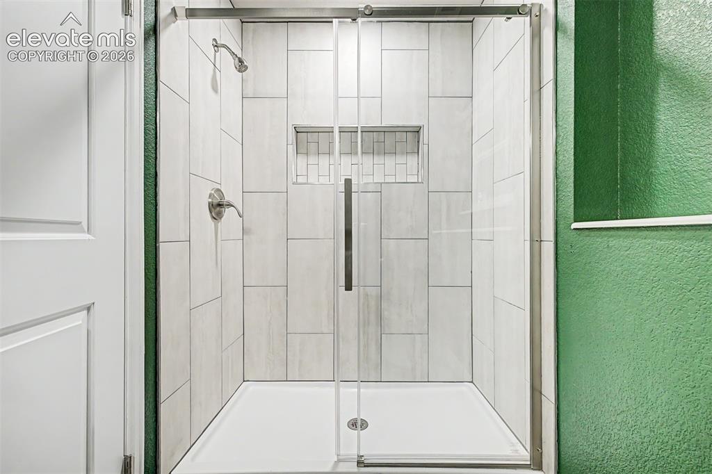 Image 28 of 44: Shower enclosure with clear glass door, brushed nickel fixtures, white tile